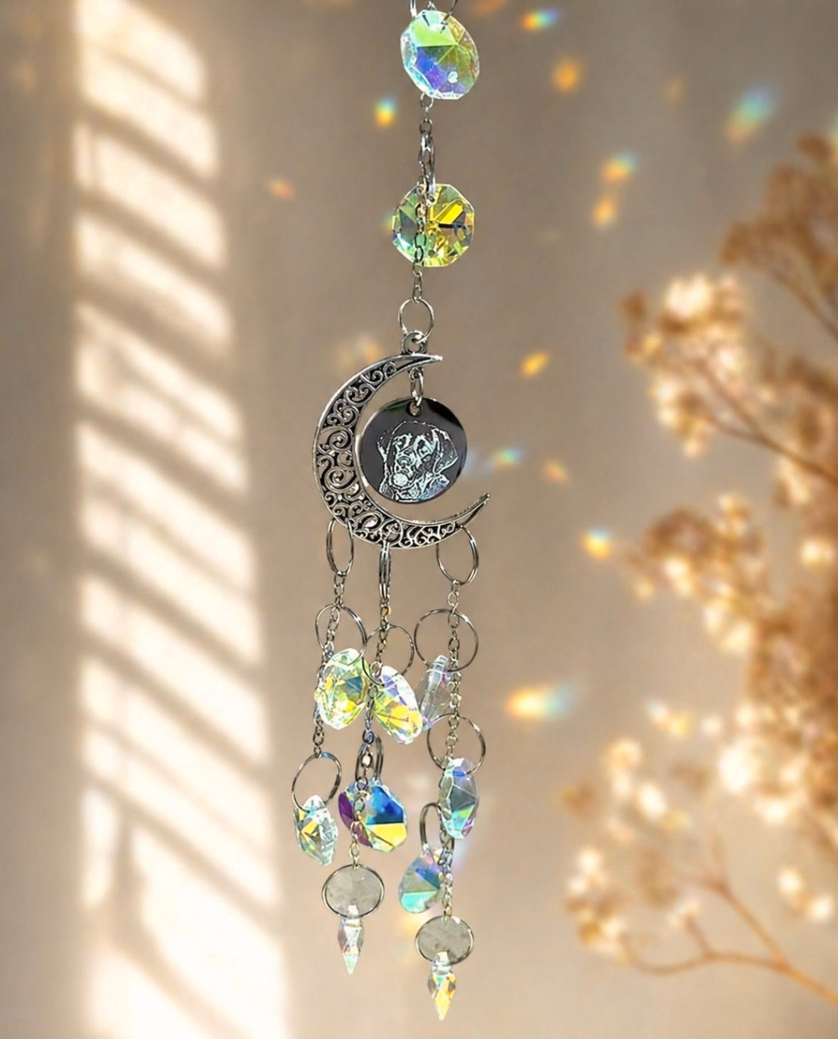 Decorative hanging crystal with moon and star design on a neutral background