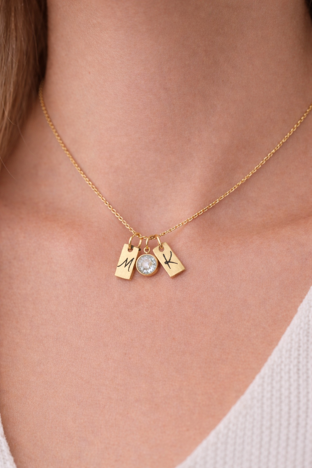 Gold necklace with charms on a person's neck