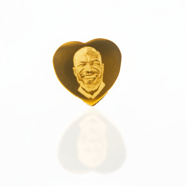 Heart-shaped gold pandora charm with a face engraving on a white background