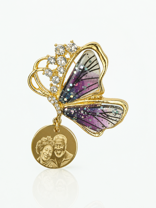 Butterfly-shaped brooch with a gold pendant featuring a couple's photo on a white background
