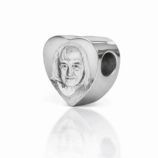 Silver pandora heart charm with a face photo engraving on a white background