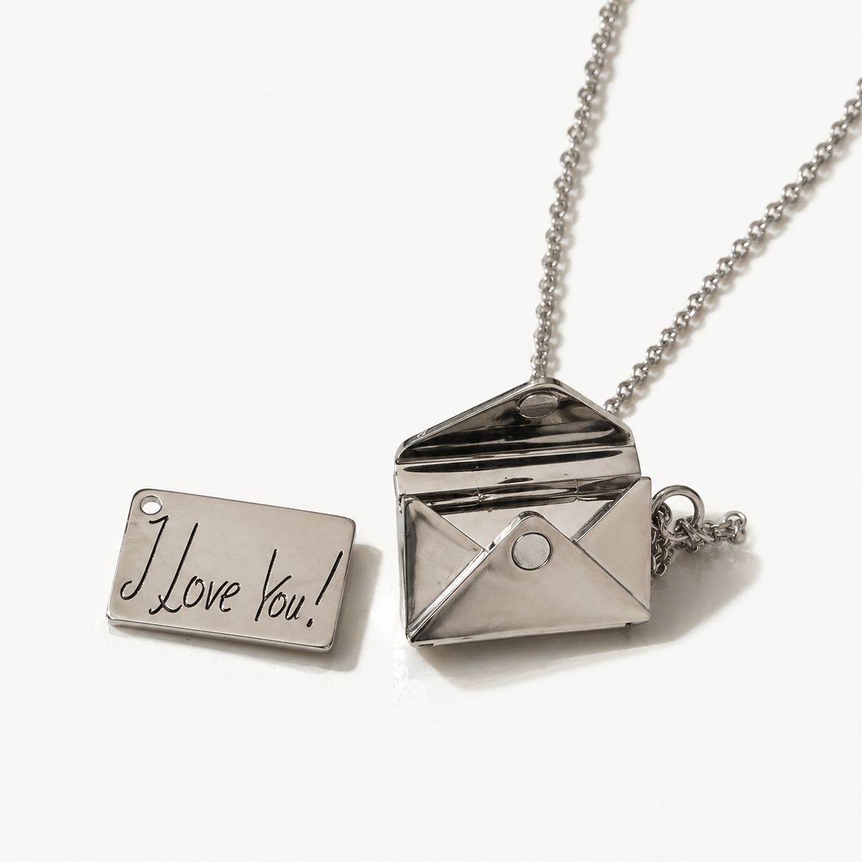 Silver necklace with an open envelope pendant and a rectangular tag reading 'I Love You!' on a white background.