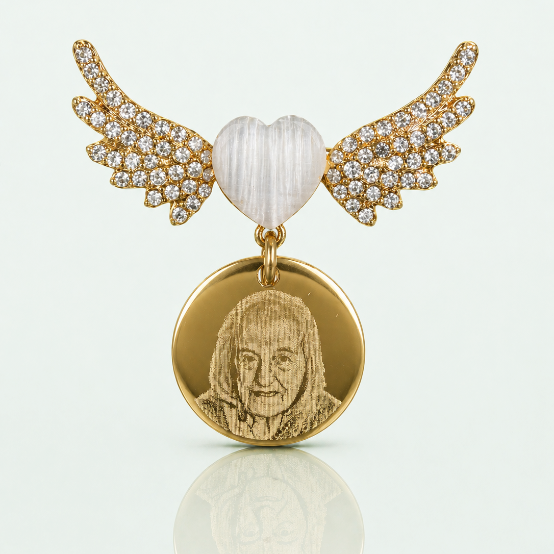 Gold pendant with heart and wings on a white background