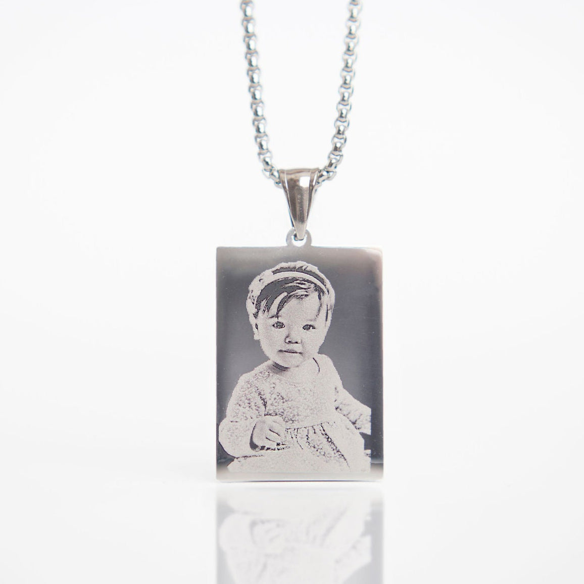 Necklace with a pendant featuring an engraved image of a child on a white background