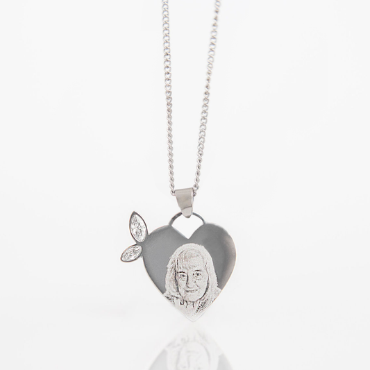 Winged heart-shaped pendant with a face engraving