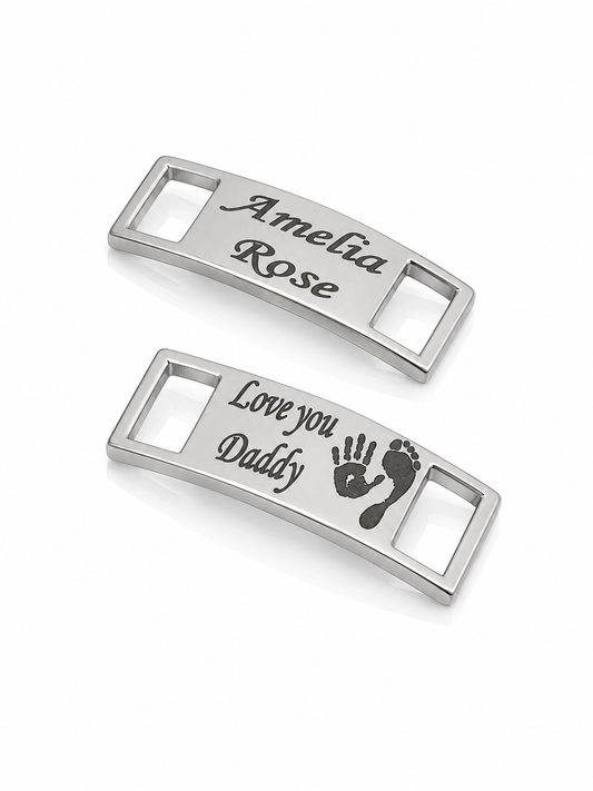 Two silver trainer charms with engraved text on a white background
