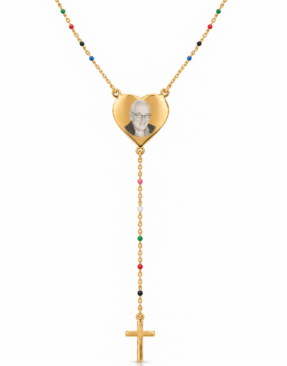 A gold-toned necklace featuring a heart-shaped pendant with a portrait engraving, connected to a rosary-style drop chain with small multicolored beads and a gold cross pendant, shown on a white background.