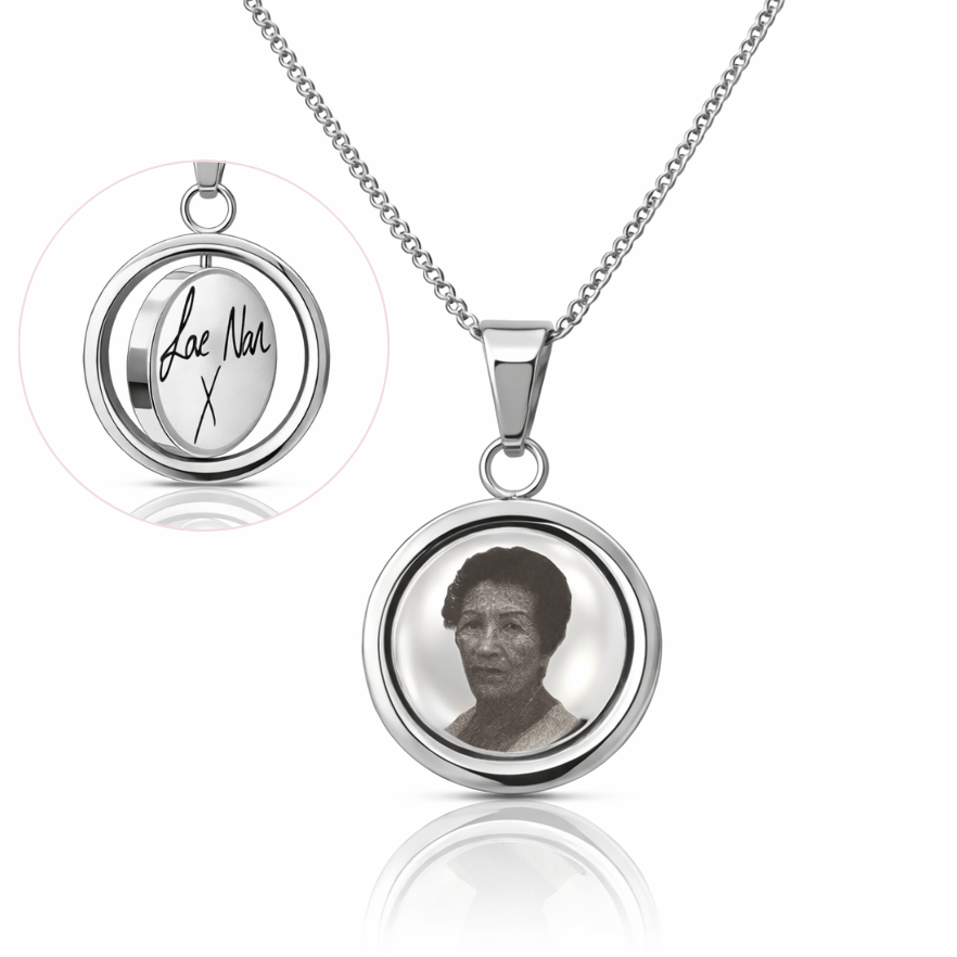 Silver necklace with a pendant featuring a photo and engraved text on a white background