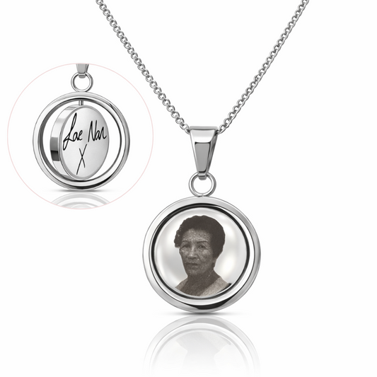 Silver necklace with a pendant featuring a photo and engraved text on a white background